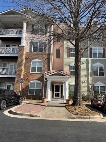 Front view of a multi-story residential building with a portico entrance.