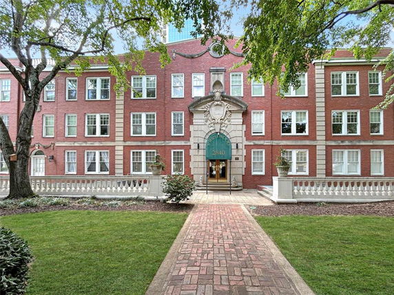Front view of a three-story brick building with decorative entryway.
