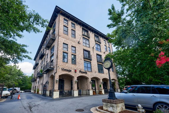 Front view of a multi-story building with a brick facade and arched entrances.