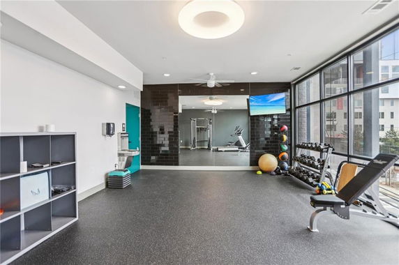 Indoor gym with exercise equipment and large windows.