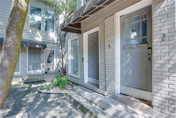 Front view of a multi-unit residential building with multiple entrance doors and windows.
