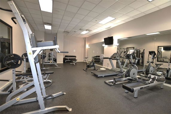 Interior view of a gym with exercise equipment such as treadmills, ellipticals, and weightlifting machines.
