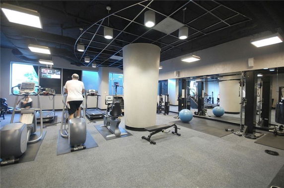 Indoor gym area with exercise equipment and mirrors.