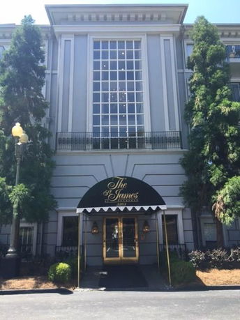 Front view of a multi-story building with large windows and an entrance canopy.