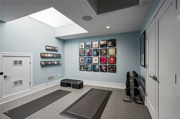 Indoor room featuring gym equipment with wall decorations.