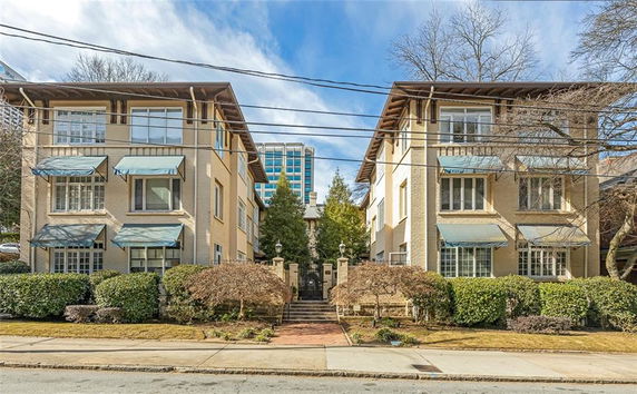 Front view of a two-story apartment building with multiple windows and entrance gate.