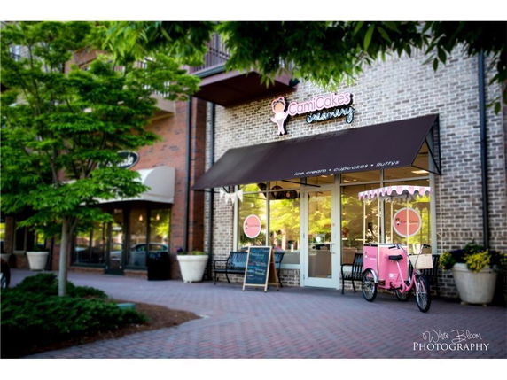 Front view of a building with a storefront featuring a brown awning and a brick exterior.