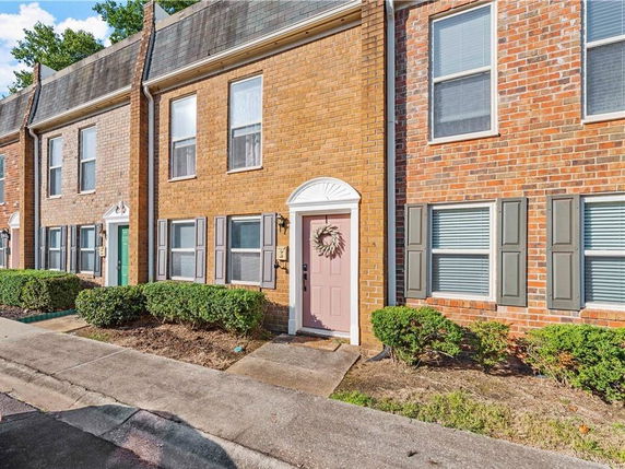 Front view of a row of brick townhouses with decorated entrances.
