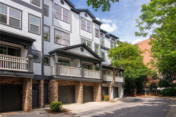 Front view of a multi-story residential building with balconies and garages.