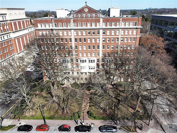 Front view of a multi-story brick building with numerous windows and a central entrance.