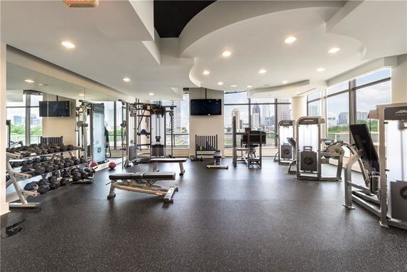 Indoor gym area with exercise equipment and large windows.