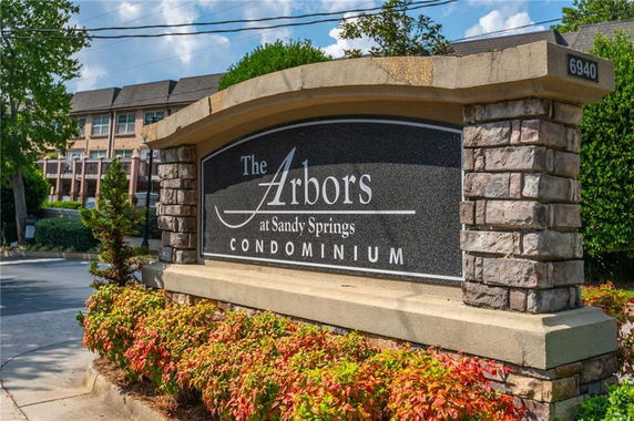 Front view of a condominium entrance sign with brick and stone construction.