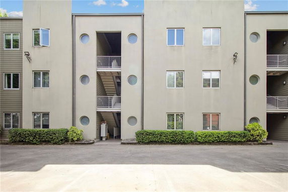 Front view of a multi-story building with symmetric windows and round accents.