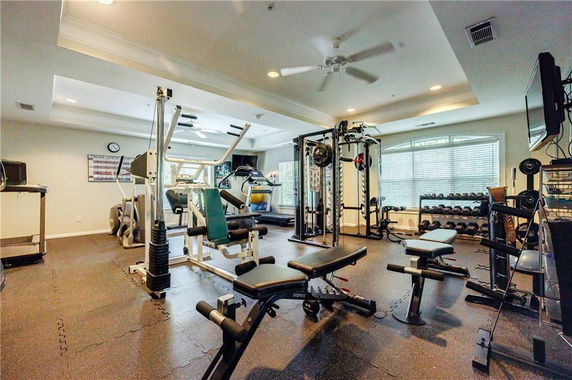 Indoor gym with various exercise equipment and weights.