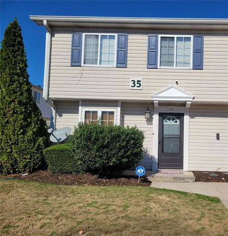 Front view of a two-story house with blue shutters and a small porch.
