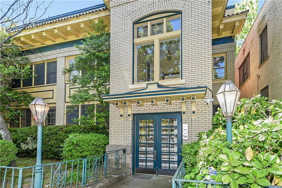 Front view of a two-story brick building with large windows and an entryway.