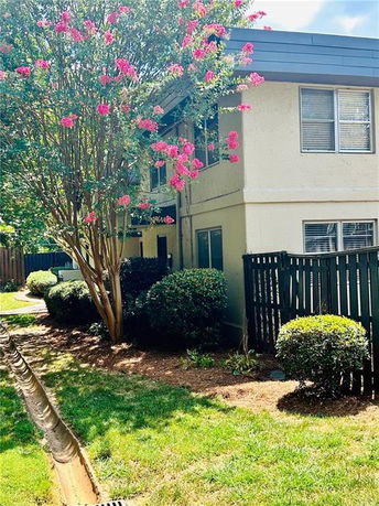 Front view of a two-story house with a fenced yard.
