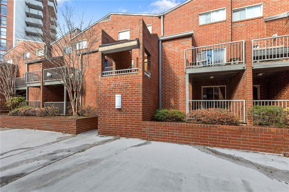 Front view of a brick multi-story building with balconies.