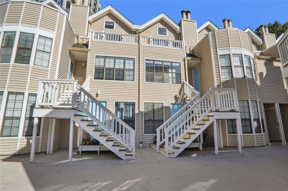 Front view of a multi-story building with two staircases leading to separate entrances.