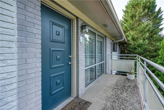 Entrance view of a building with a blue door and balcony railing