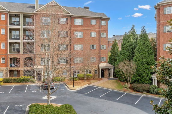 Front view of a multi-story residential building with parking spaces.