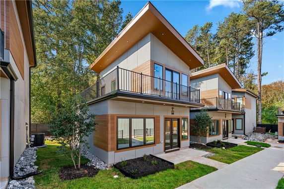 Front view of a modern two-story house with large windows and balconies.