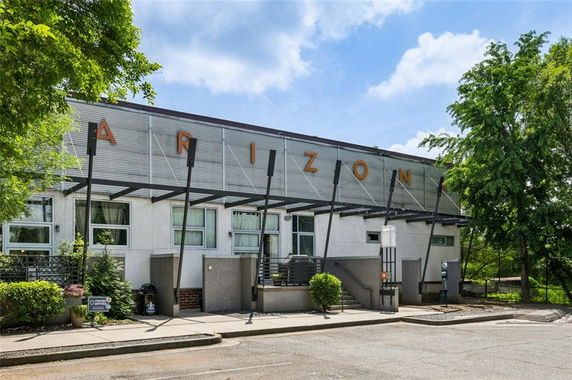 Front view of a modern two-story building with large windows and metal accents.