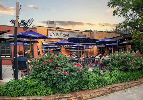 Front view of a building with outdoor seating and umbrellas.