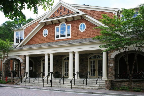 Front view of a building with multiple columns and shingled siding.