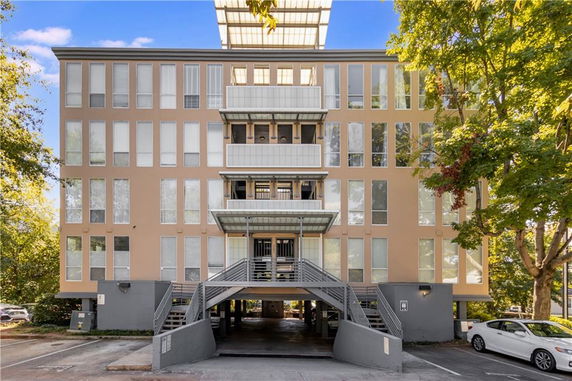 Front view of a multi-story building with large windows and a central staircase leading to the entrance.