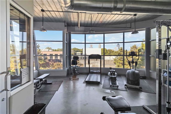 Gym area with exercise equipment and large windows overlooking the surroundings.