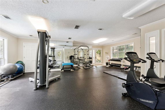 Indoor gym area with equipment including exercise bikes and weights.