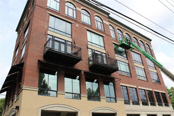 Front view of a multi-story brick building with large windows and balconies.