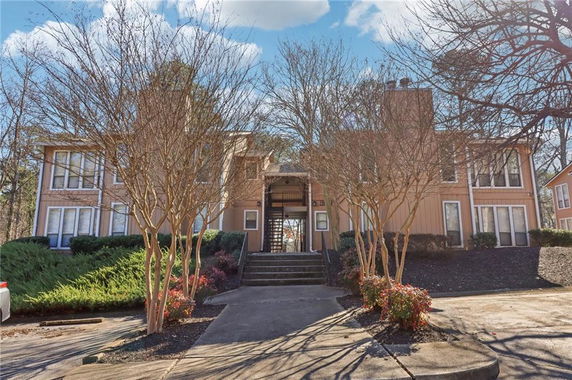 Front view of a two-story residential building with multiple windows and a central entrance.