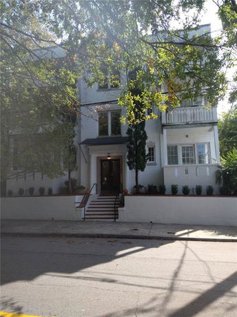 Front view of a multi-story building with a small balcony.