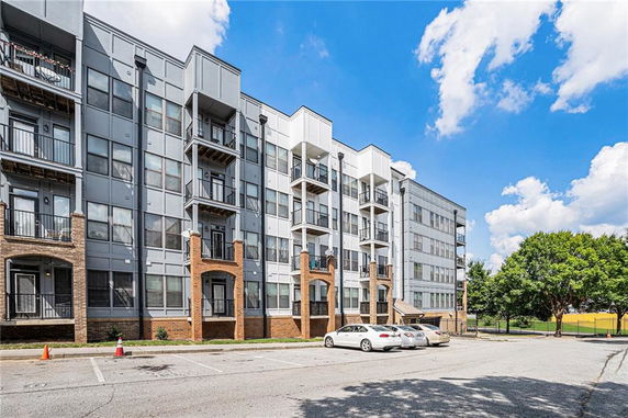Front view of a modern multi-story apartment building with balconies.