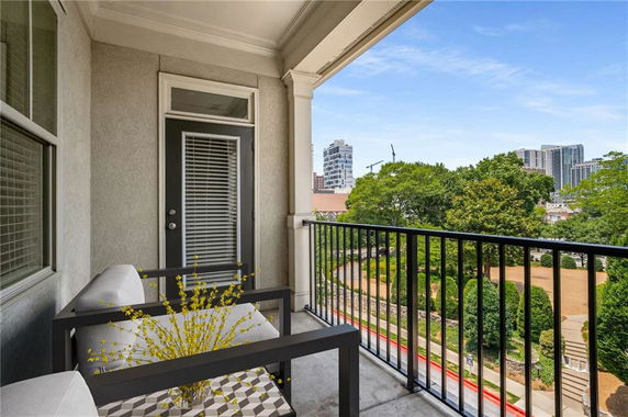 Balcony view with surrounding cityscape and greenery.