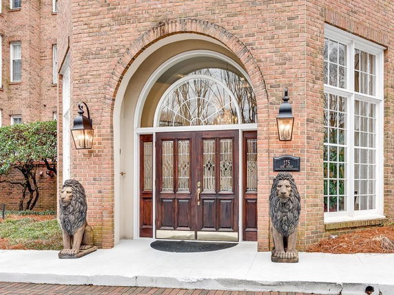 Front entrance of a building with arched design and lion statues.
