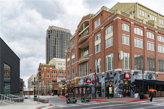 Front view of a multi-story urban building with street-level shops.