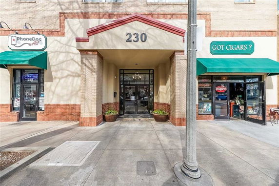 Front view of a commercial building with entrance and adjacent shops.