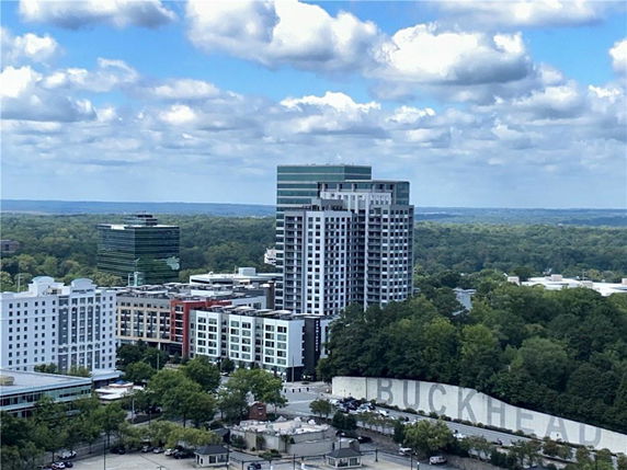 Panoramic view of a cityscape with several high-rise buildings and surrounding greenery.