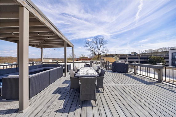 Rooftop area with seating, dining table, and pergola structure.
