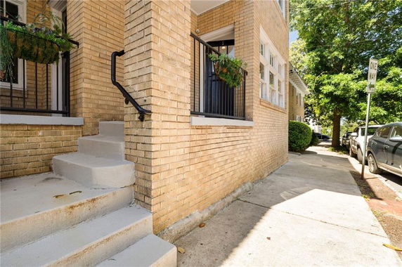 Close-up view of a brick exterior with steps leading to an entrance.