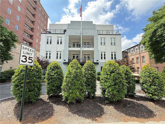 Front view of a multi-story building with central entrance and landscaping.