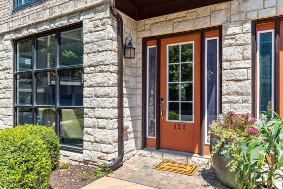 Front view of a house with stone exterior and a glass door with sidelights.