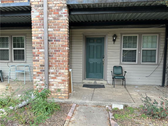 Front view of a house with a brick pillar and green door.