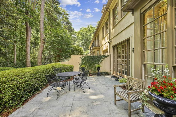 Side view of a house with a patio area and garden seating.