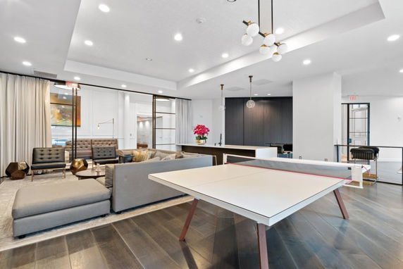 Interior of a recreation room with modern furnishings and a ping pong table.