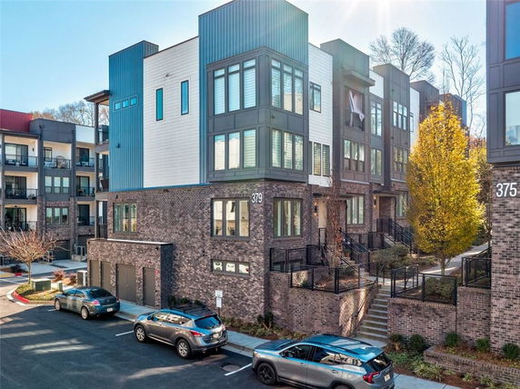 Front view of a modern multi-story townhouse with brick and panel facade.