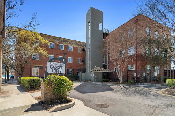 Front view of a brick building with multiple stories and an elevator shaft.